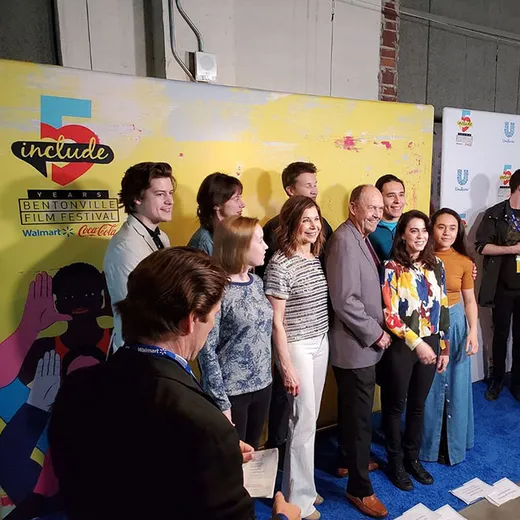 Guests lined up on a step-and-repeat at a premiere