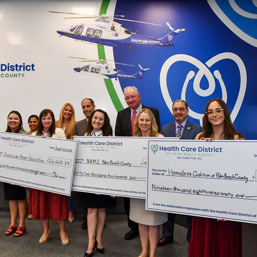 Ceremonial cheque presentation in front of a medical helicopter