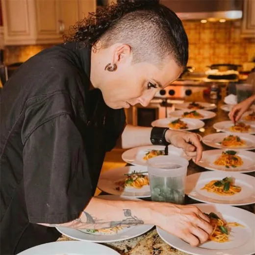 Chef plating dishes on a catering line